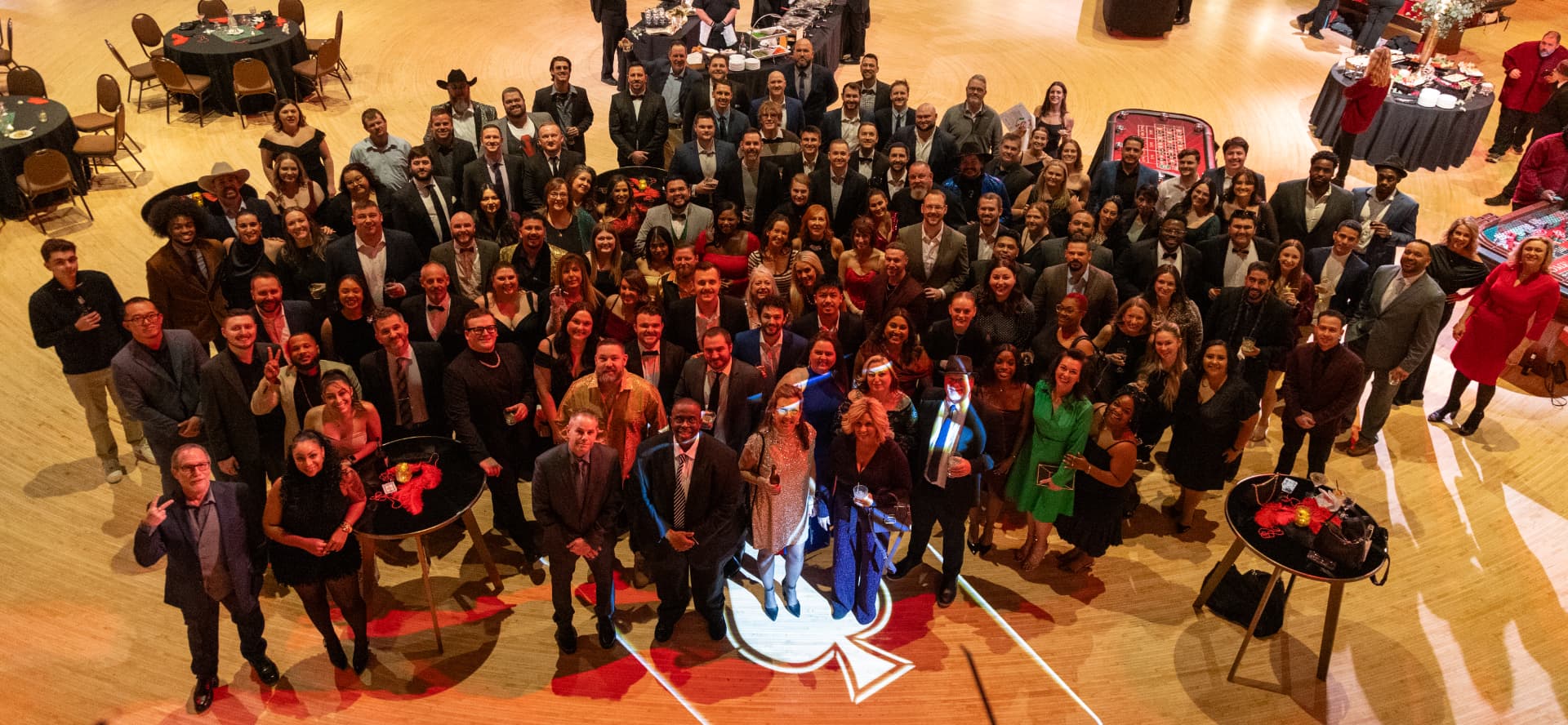 The whole company gathered on the ballroom dance floor at the 2026 holiday party