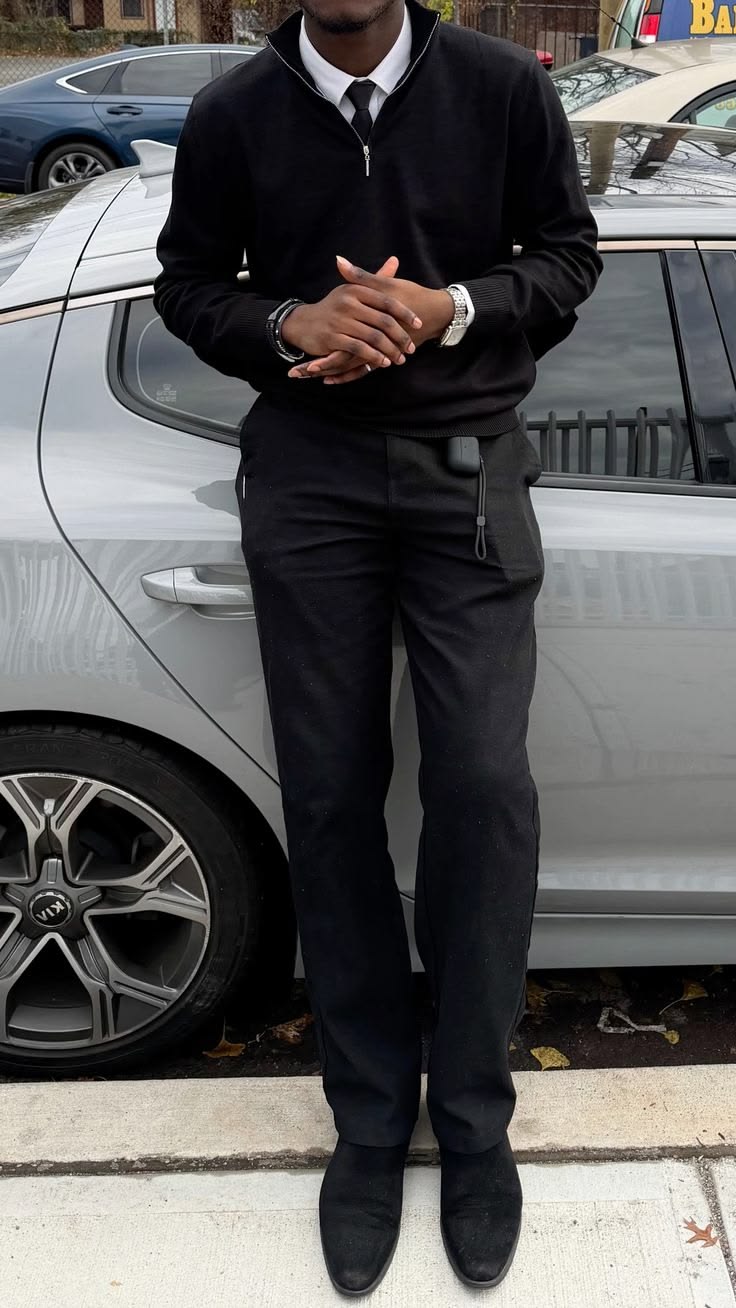 Black quarter-zip knit over a white shirt and slim black tie